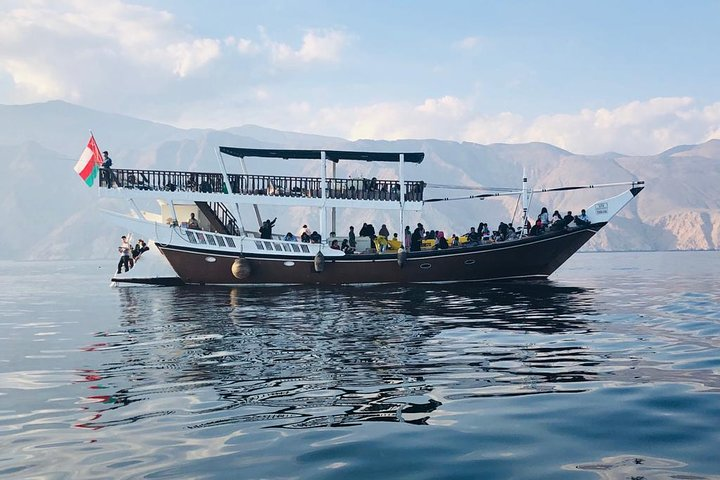 Experience the charm of Musandam on a dhow cruise surrounded by stunning landscapes while enjoying activities like snorkeling fishing and water sports creating unforgettable memories.